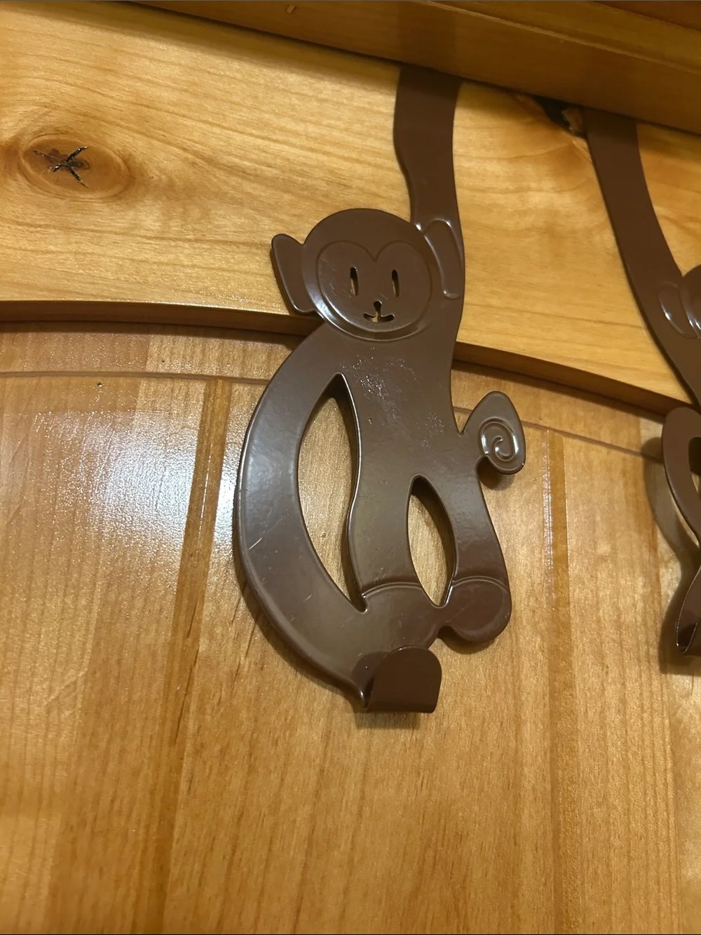 A set of 3 whimsical brown metal monkey over-the-door hooks